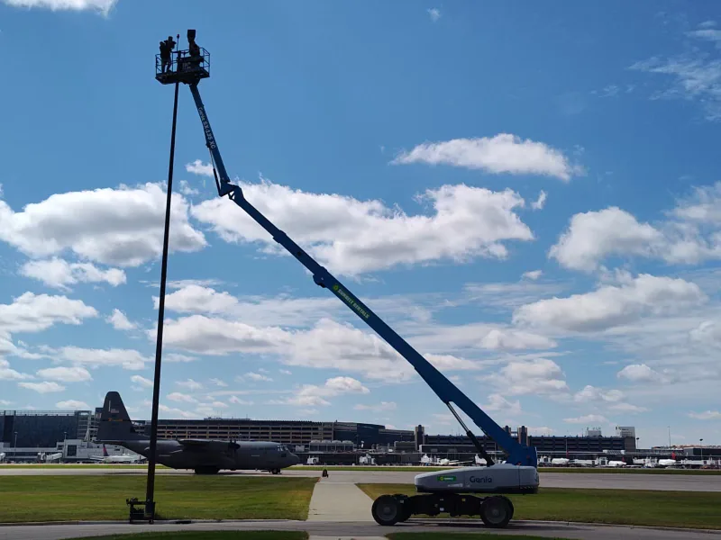 Crew on an elevated lift working beside aircraft at Minneapolis–Saint Paul International Airport.
