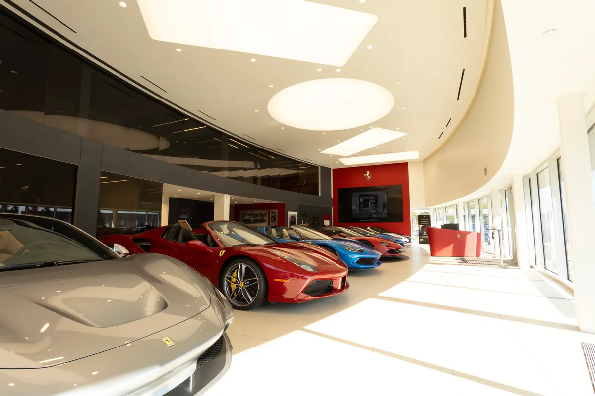 Ferrari showroom with specialty lighting and vehicles on display.