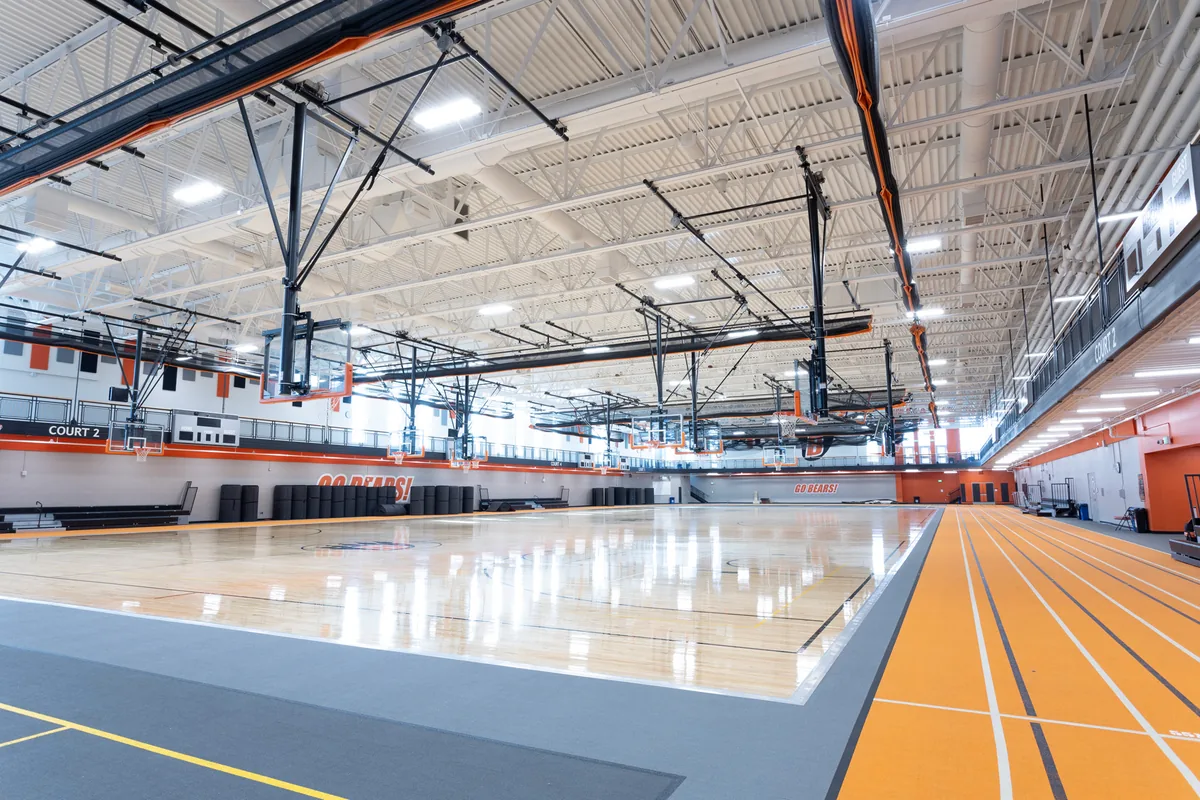 Completed White Bear Lake High School gymnasium with overhead electrical installations.
