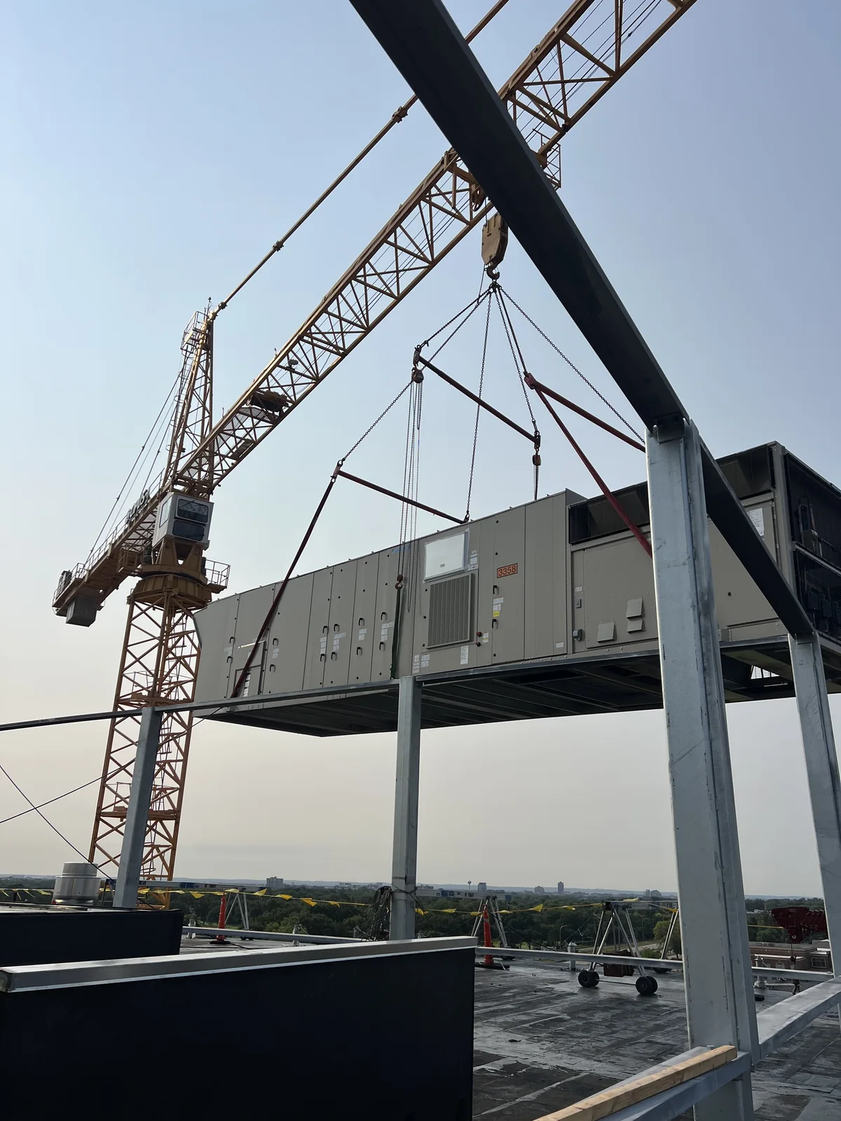 A crane lifting HVAC equipment into the steel structure at OPUS–Arcadia.