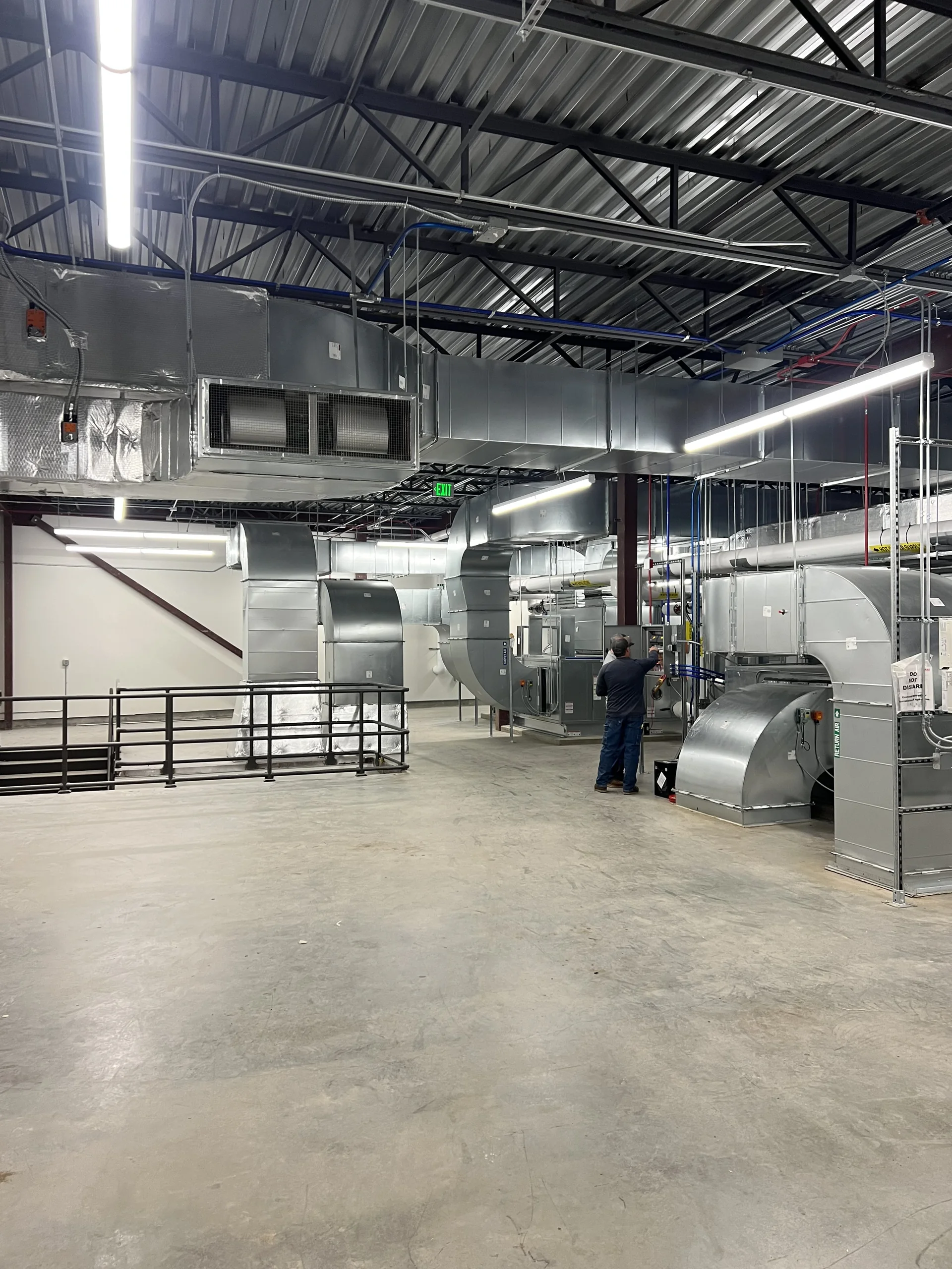 Installed metal ductwork and HVAC equipment inside the OPUS–Arcadia project.