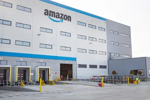 Exterior of an Amazon facility with loading bays and blue-trimmed entrances.