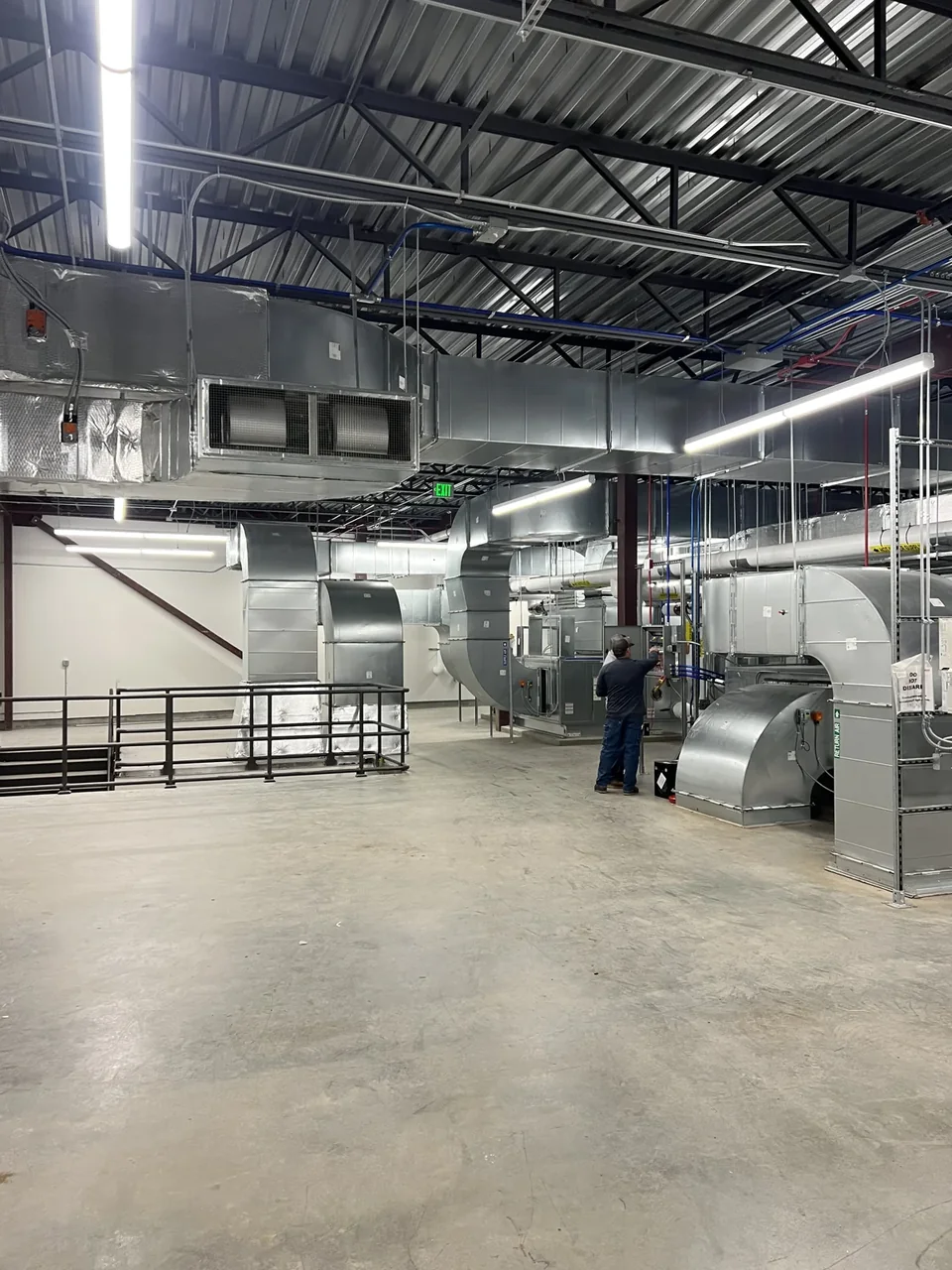 Installed metal ductwork and HVAC equipment inside the OPUS–Arcadia project.