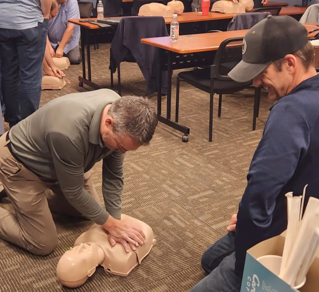 Muska employees practicing CPR on a training mannequin