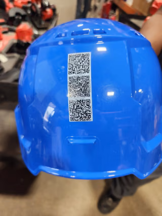 Blue hard hat with QR-code stickers for safety resources